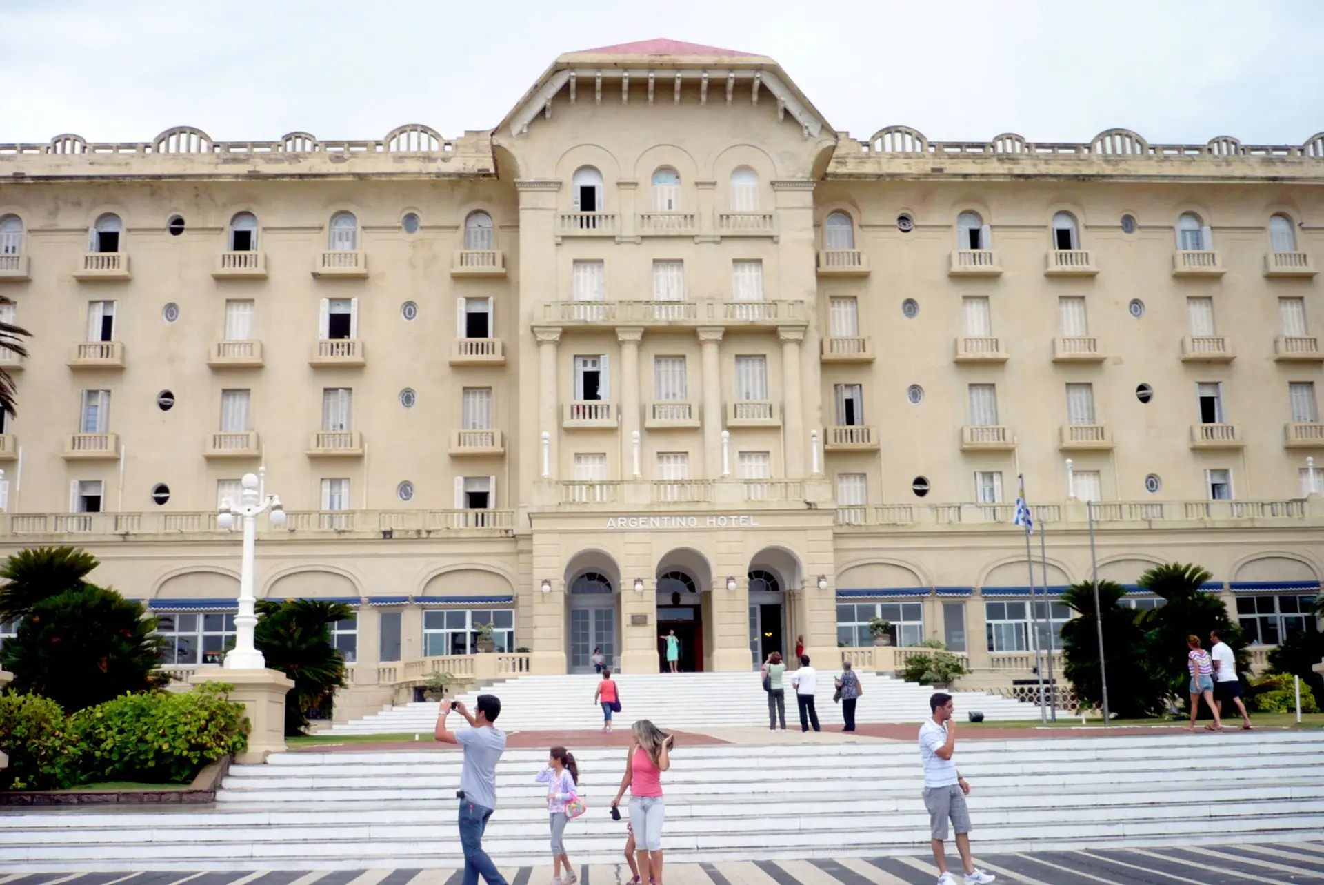Fachada del Argentino Hotel de Piriápolis, con gente subiendo la escalinata en un día de sol